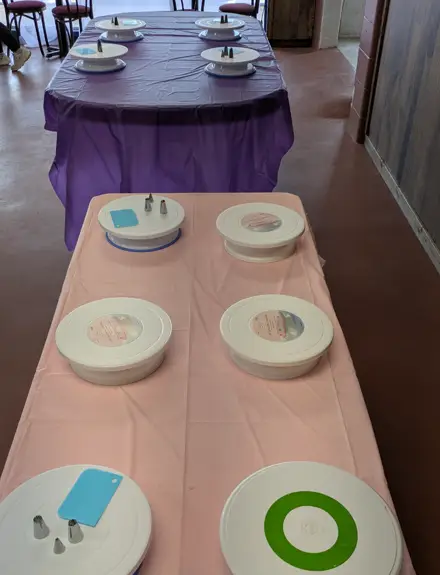 Tables set up with plates and supplies for a Kozy Cakes decorating party